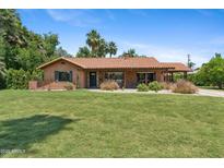 Charming single-story home with a red tile roof and a lush green lawn in a sunny setting at 20 W Pasadena Ave, Phoenix, AZ 85013