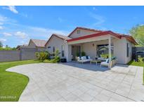 Expansive backyard with neutral colored hardscape, covered patio and comfortable seating area at 2028 W Alice Ave, Phoenix, AZ 85021