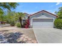 Charming single-story home with a two-car garage, xeriscape landscaping, and mature desert plants at 2028 W Alice Ave, Phoenix, AZ 85021