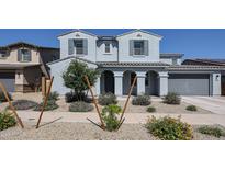 Charming two-story home featuring a well-manicured front yard and a welcoming covered entryway at 25051 N 140Th Dr, Surprise, AZ 85387