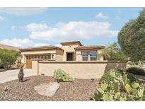 A tan single-story home features desert landscaping, a private courtyard, and an attached two-car garage at 27023 N 130Th Gln, Peoria, AZ 85383