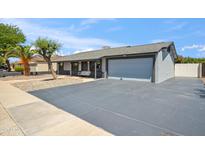 Charming single-story home featuring a large driveway, well-kept yard and a delightful front porch swing at 2708 E Villa Theresa Dr, Phoenix, AZ 85032