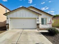 Charming single-Gathering home featuring a white exterior, two-car garage, and desert landscaping at 4891 E Meadow Mist Ln, San Tan Valley, AZ 85140
