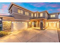 Inviting home exterior featuring a three-car garage and meticulously landscaped front yard at twilight at 4960 E Colonial Dr, Chandler, AZ 85249