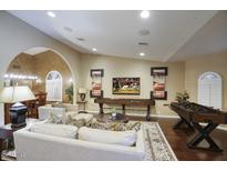 Open living area with hardwood floors, comfortable seating, and a media center at 5672 E Beverly Ln, Scottsdale, AZ 85254