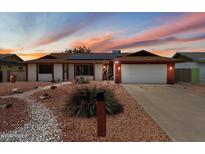 Charming single-story home with desert landscaping, solar panels, and a two-car garage at 5808 W Acoma Dr, Glendale, AZ 85306