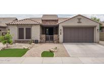Charming home exterior featuring a well-manicured lawn, a brick walkway, and a two-car garage at 9041 W Redbird Rd, Peoria, AZ 85383