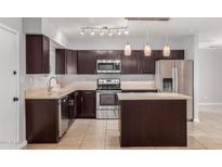 Modern kitchen featuring stainless steel appliances, an island, and dark wood cabinetry at 1002 W Villa Rita Dr, Phoenix, AZ 85023