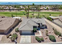An aerial view of a single-Gathering home showcases the well-kept desert landscape and nearby golf course at 15371 W Piccadilly Rd, Goodyear, AZ 85395
