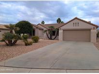Charming single-story home with a well-maintained yard, complemented by a spacious driveway leading to a two-car garage at 16313 W Escondido Ct, Surprise, AZ 85374
