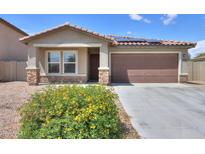 Charming single-Gathering home featuring a tile roof, two-car garage, desert landscaping, and a cozy front porch at 1652 E Judi St, Casa Grande, AZ 85122