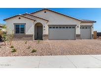 Charming single-story home with desert landscaping, brick driveway, and a two-car garage at 18174 W Ashley Dr, Goodyear, AZ 85338