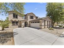 Charming two-story home featuring a three-car garage and a well-maintained front yard with mature trees at 18390 W Hayden Dr, Surprise, AZ 85374