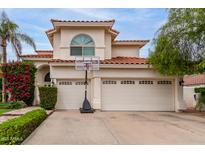 Charming two-story home with a three-car garage, red tile roof, basketball hoop and beautiful desert landscaping at 2026 E Cortez Dr, Gilbert, AZ 85234