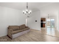 Bright living room featuring modern lighting and light-colored wood flooring at 3646 N 67Th Ave # 20, Phoenix, AZ 85033