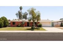 Charming single-story brick home featuring a well-maintained front yard, two-car garage, and mature landscaping at 3741 W Davidson Ln, Phoenix, AZ 85051