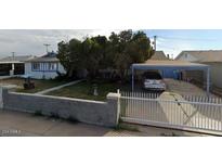 Charming single-story home with a covered carport and mature trees at 5833 W Rosewood Ln, Phoenix, AZ 85031