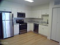Bright kitchen featuring stainless steel appliances, marble countertops and white cabinetry at 720 S Dobson Rd # 95, Mesa, AZ 85202