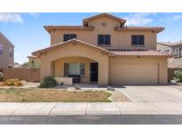 Charming two-story home with a well-maintained front yard and a two car garage at 13313 W Indianola Ave, Litchfield Park, AZ 85340
