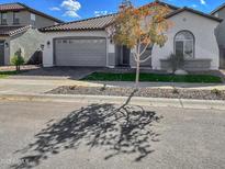 Charming single-story home featuring a gray tile roof, landscaped front yard, and a two car garage at 15787 W Mariposa Grande St, Surprise, AZ 85387