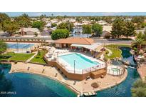 Beautiful community pool with lounge chairs, tennis court, and a scenic lake view at 1601 E Cindy E St, Chandler, AZ 85225