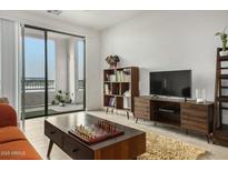 Bright living room with stylish furniture, media center, and sliding glass doors to balcony at 2511 W Queen Creek Rd # 378, Chandler, AZ 85248