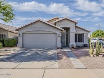 Charming single-story home with desert landscaping, a two-car garage and a covered front porch at 2550 E Caballero St, Mesa, AZ 85213