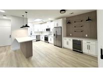Bright kitchen features stainless steel appliances, island with seating and wood panel accent wall with shelving at 3221 N 37Th St # 26, Phoenix, AZ 85018
