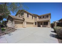 Two-story home featuring a three-car garage and a well-manicured front yard at 40724 W Novak Ln, Maricopa, AZ 85138