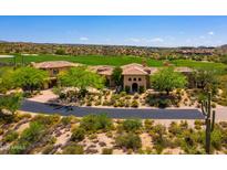 Stunning view of the tile roofed luxury home set adjacent to a lush golf course and beautiful desert landscape at 40853 N 94Th St, Scottsdale, AZ 85262