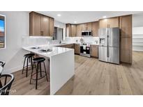 Updated kitchen with stainless steel appliances, custom cabinets, and modern countertops at 6038 E Hobart St, Mesa, AZ 85205