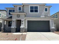 Charming two-story home featuring a gray stucco exterior, a two-car garage, and a well-manicured front yard at 7404 W Buckhorn Trl, Peoria, AZ 85383