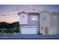 Modern two-story home with a two-car garage and light gray and white siding at dusk at 7437 S 75Th Dr, Laveen, AZ 85339