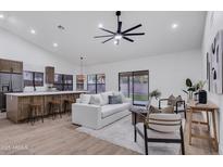 Bright living room featuring an open floor plan, ceiling fan, and sliding glass door to the backyard at 1142 E Encinas Ave, Gilbert, AZ 85234