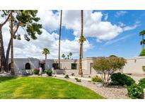 Expansive front yard featuring lush green grass, mature trees, and a well-maintained landscape at 12 E Seminole Dr, Phoenix, AZ 85022