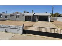 Charming gray home featuring a covered carport, black iron gate, and a low-maintenance yard at 1630 E Catalina Dr, Phoenix, AZ 85016