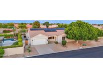 Charming single-story home featuring a well-manicured lawn, solar panels, and a two-car garage at 18161 N 63Rd Ln, Glendale, AZ 85308