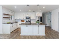 Bright kitchen with white cabinetry, stainless steel appliances, and an island with pendant lighting at 1820 W Seldon Way, Phoenix, AZ 85021