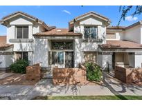 Inviting home exterior showcases a well-manicured lawn, brick accents, and gated entrance at 2201 N Comanche Dr # 1094, Chandler, AZ 85224