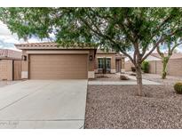 Tan home featuring a two car garage, desert landscaping, and a sidewalk leading to the front door at 3212 W Lucia Dr, Phoenix, AZ 85083