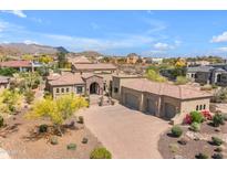 Aerial view of a desert community home with a tile roof, lush landscaping, and multi-car garage at 3217 N Piedra Cir, Mesa, AZ 85207