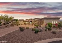 Desert landscaping surrounds this luxury home with an arched entryway and tile roof at 3217 N Piedra Cir, Mesa, AZ 85207