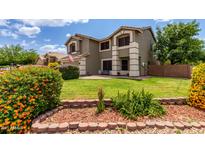 Beautifully landscaped front yard with lush lawn, colorful bushes, and a charming two-story home at 3730 S Chaparral Rd, Apache Junction, AZ 85119