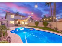 Inviting backyard oasis with a refreshing pool, lush greenery, and a cozy outdoor seating area at 4106 E Muirwood Dr, Phoenix, AZ 85048
