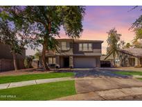 Charming two-story home with a well-manicured lawn and mature trees at 424 W Midland Ln, Gilbert, AZ 85233