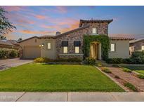 Charming stone home with a well-manicured lawn, flower beds, and a brick walkway leading to the front door at 5226 S Fairchild Ln, Chandler, AZ 85249