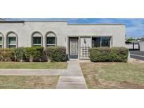 Charming single-story stucco home featuring arched windows and lush landscaping enhancing curb appeal at 5809 E Thomas Rd, Scottsdale, AZ 85251