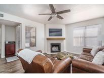 Inviting living room with a cozy fireplace, modern ceiling fan, and comfortable leather seating at 8787 E Mountain View Rd # 2008, Scottsdale, AZ 85258