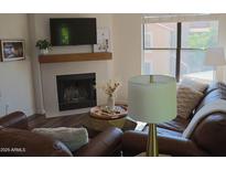Cozy living room with a fireplace, TV, and comfortable seating at 8787 E Mountain View Rd # 2008, Scottsdale, AZ 85258