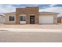 Charming single-story home featuring a stacked stone entry and a two car garage at 10022 S 37Th Ave, Laveen, AZ 85339